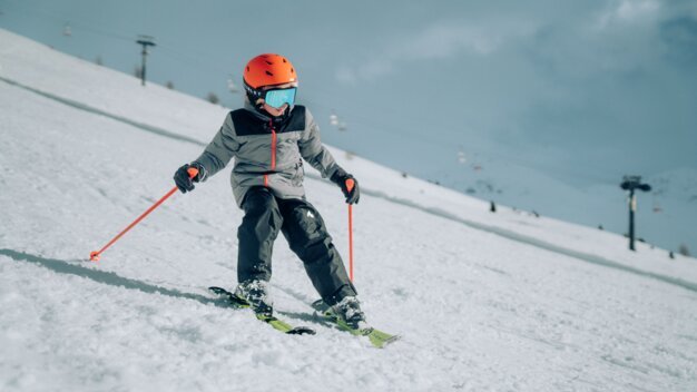 Kind beim Skifahren auf einer schneebedeckten Piste