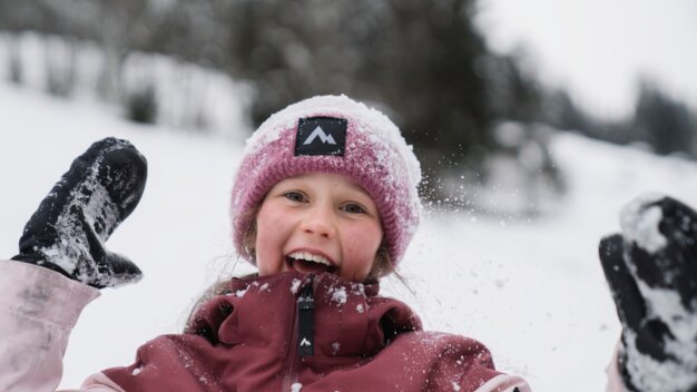 Lachendes Mädchen im Schnee mit Mütze und Handschuhen. | © INTERSPORT International Corporation GmbH