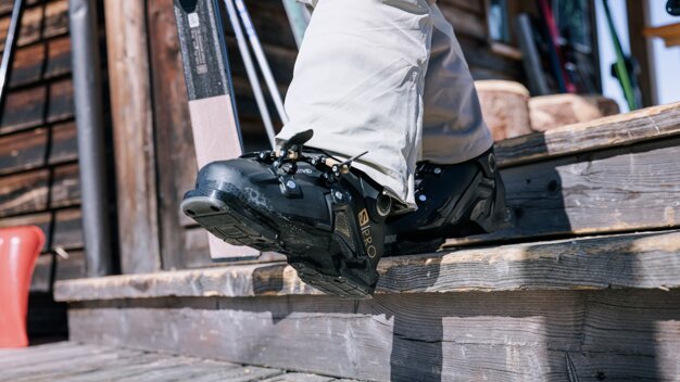 Person mit Skischuhen auf einer Holztreppe. | © IIC - INTERSPORT International Corporation GmbH