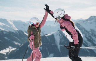Due sciatrici si danno il cinque davanti a una catena montuosa. | © INTERSPORT International Corporation GmbH
