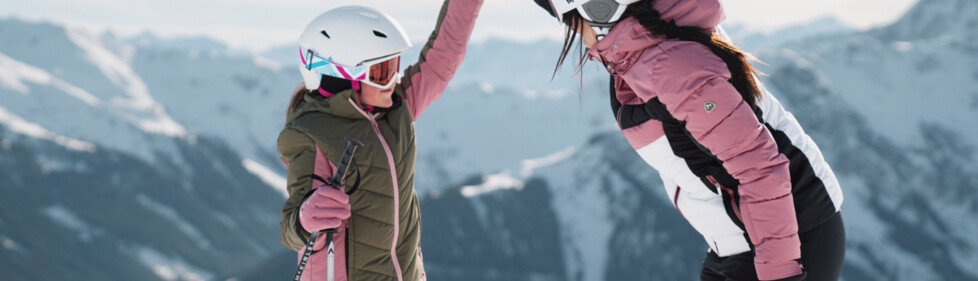 Due sciatrici si danno il cinque davanti a una catena montuosa. | © INTERSPORT International Corporation GmbH