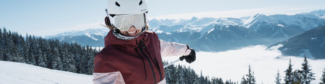Donna che scia sulla neve con montagne sullo sfondo. | © INTERSPORT International Corporation GmbH