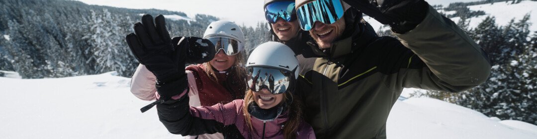 © INTERSPORT International Corporation GmbH Gruppo di quattro sciatori che salutano in montagna. | © INTERSPORT International Corporation GmbH