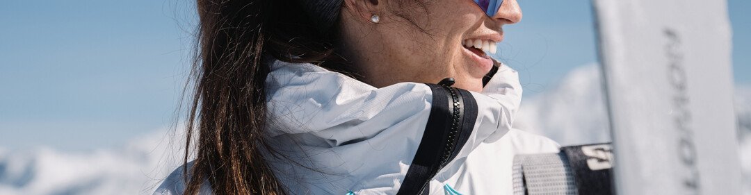 © INTERSPORT International Corporation GmbH Donna sorridente con occhiali da sole e attrezzatura da sci | © INTERSPORT International Corporation GmbH
