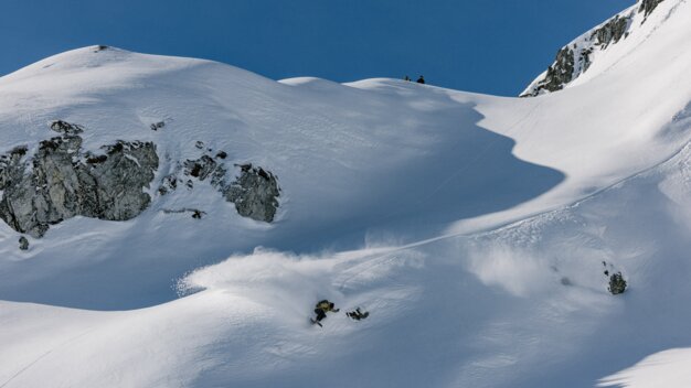 Snowboarder fährt einen verschneiten Hang hinunter. | © Salomon