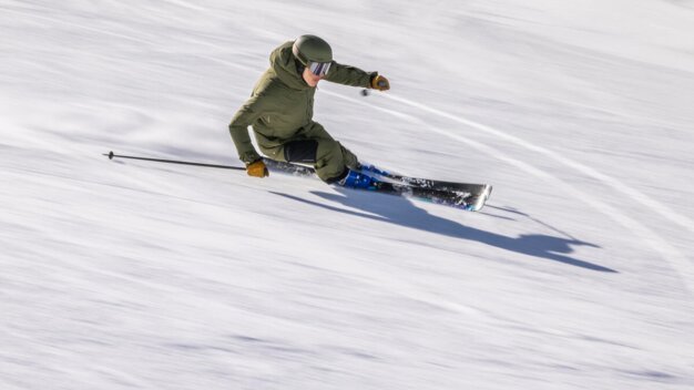 Skifahrer fährt einen Hang hinunter.