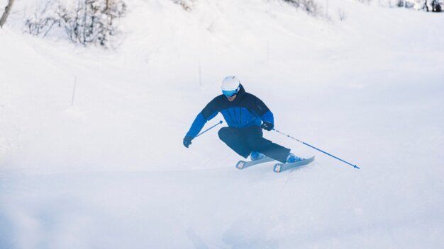 Skifahrer fährt auf einer schneebedeckten Piste