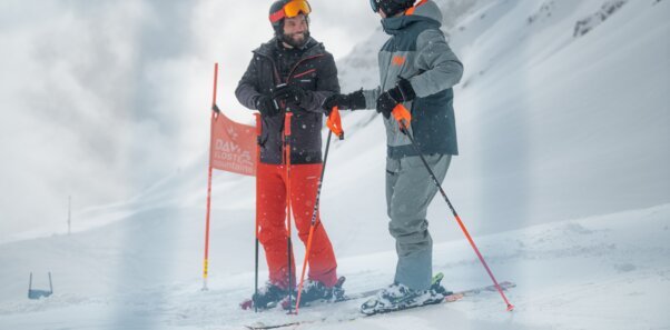 Zwei Skifahrer unterhalten sich im Schnee.