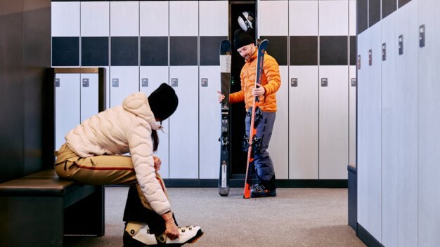 Zwei Personen bereiten sich in einem Skiraum vor. | © ARMIN WALCHER