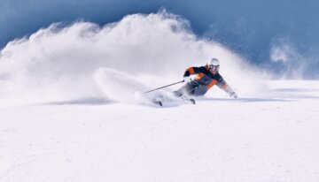 Sciatore che curva nella neve fresca | © ARMIN WALCHER