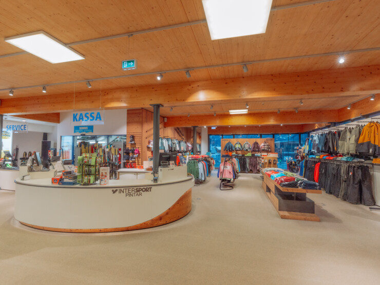 Spacious sports shop interior with checkout area, clothing and equipment displayed across the rental location interior