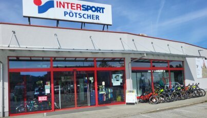 Negozio Intersport Pötscher con biciclette esposte di fronte.