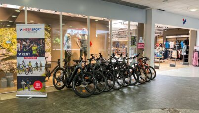 Noleggio biciclette di fronte a un negozio Intersport