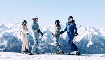 4 skiers stand on the slope and look at each other